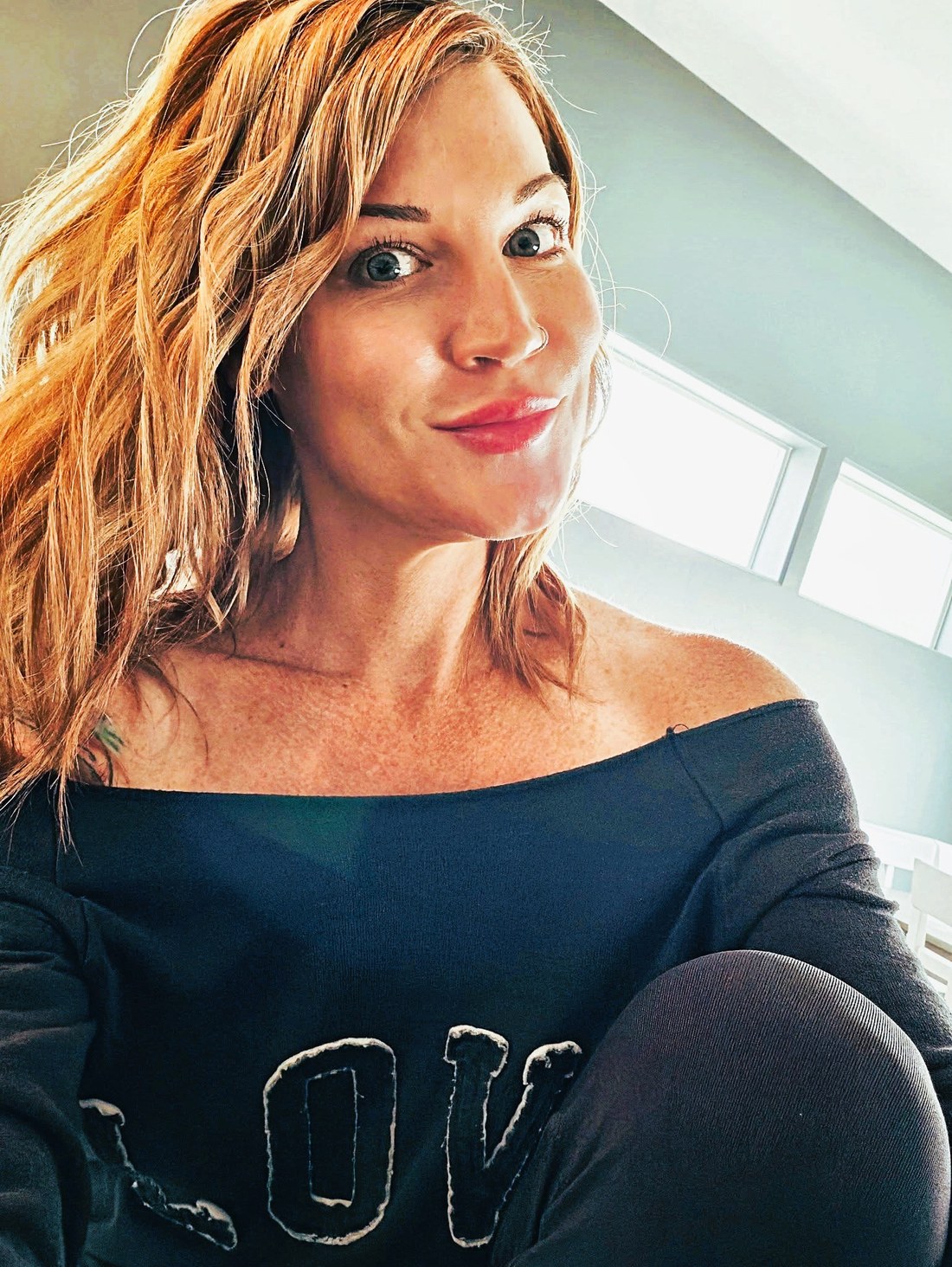 Lindsey Estes smiling in a cozy sweater, ready to talk